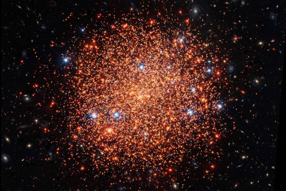 Deep telescope view of an ancient globular star cluster, a spherical swarm of thousands of old orange and red stars against dark space